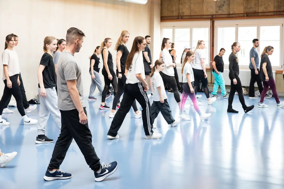 anzworkshop mit Arina Luisa: Gruppe von Teilnehmenden trainiert gemeinsam moderne Choreografie in einem hellen Tanzstudio – Bewegung, Technik und Community im Fokus.